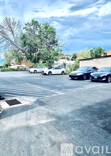 A parking lot with cars and trees in the background.