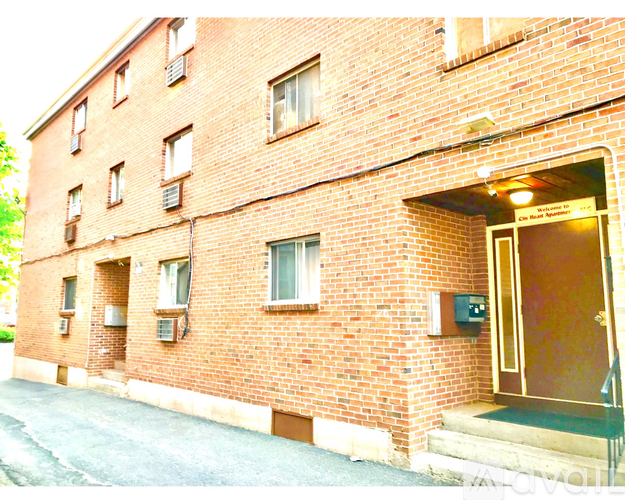 A red brick building with a doorway open to the sidewalk.