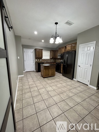 A kitchen with tile flooring and a chandelier.