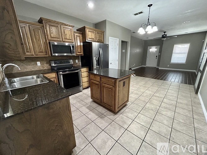 A kitchen with wooden cabinets and a black granite countertop.