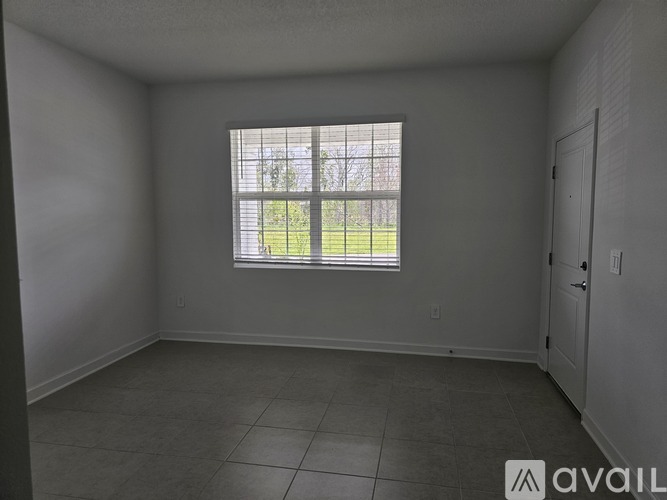 A room with a window overlooking a grassy area.