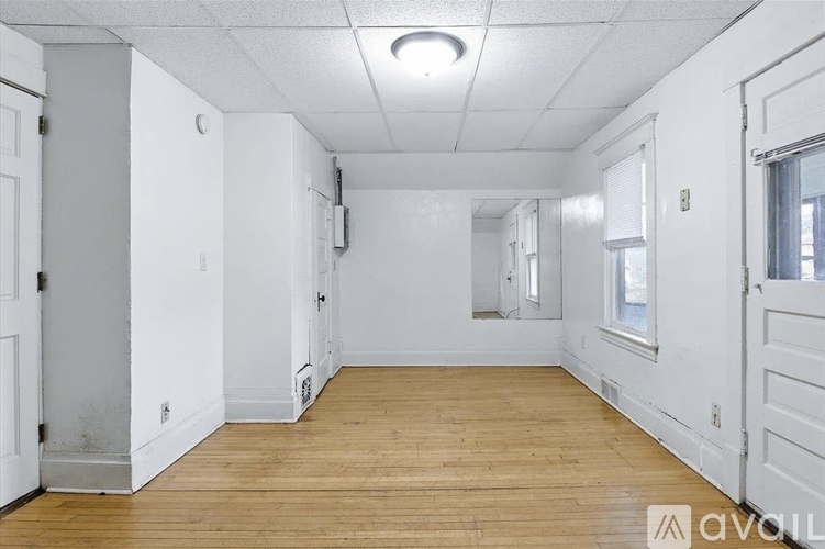 A bedroom with a brown door and a white wall.