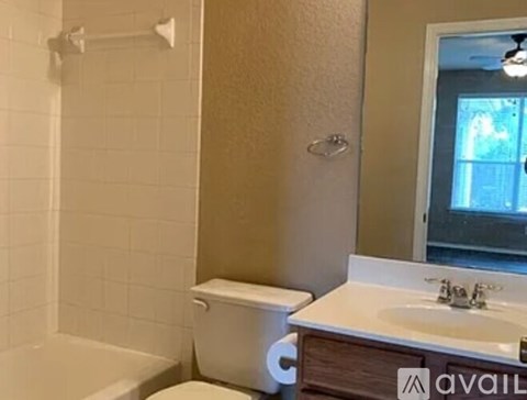 A bathroom with a toilet, sink, and bathtub.