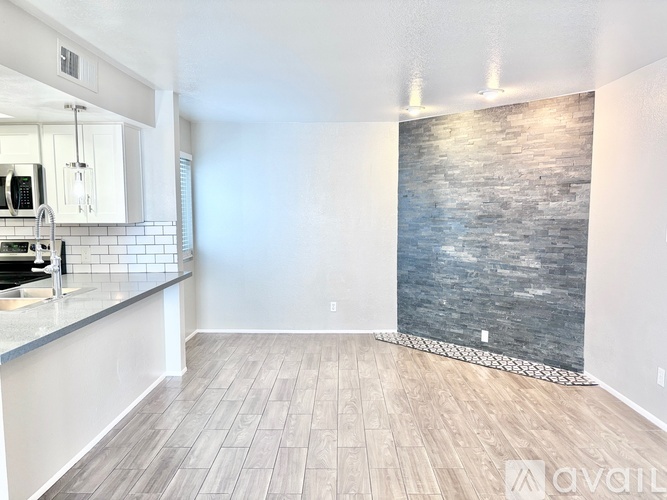 A kitchen with white cabinets and a wooden floor.