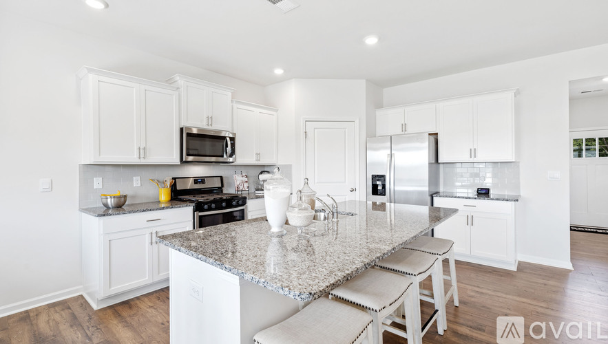 A kitchen with white cabinets and a granite countertop.