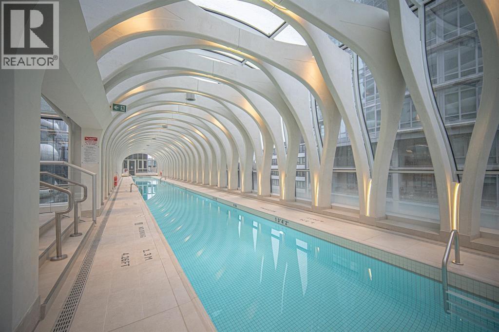 A long indoor swimming pool with a white ceiling.
