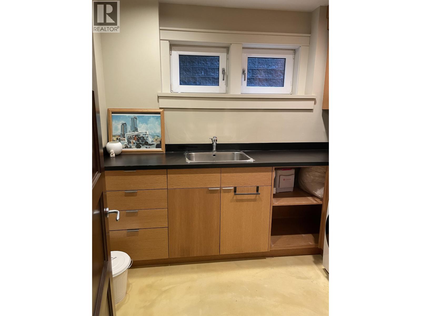 A bathroom with a sink, toilet, and a window.