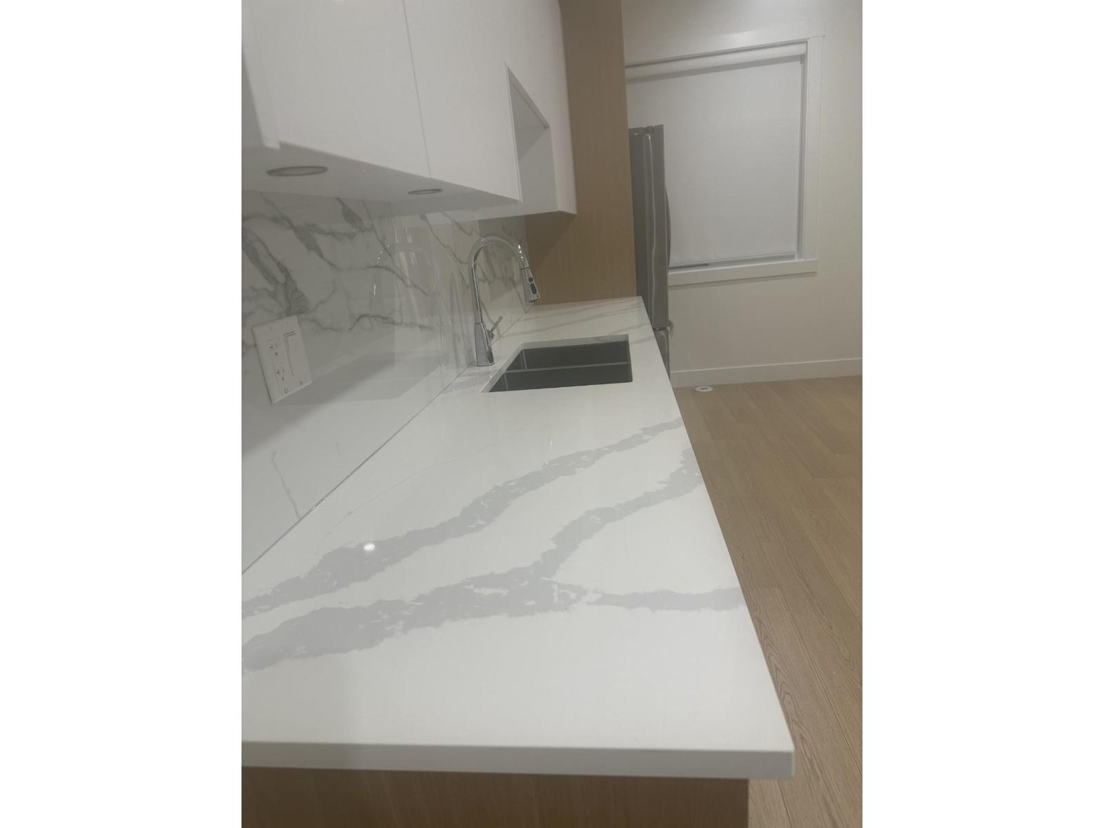 A kitchen counter with a tablet on it.