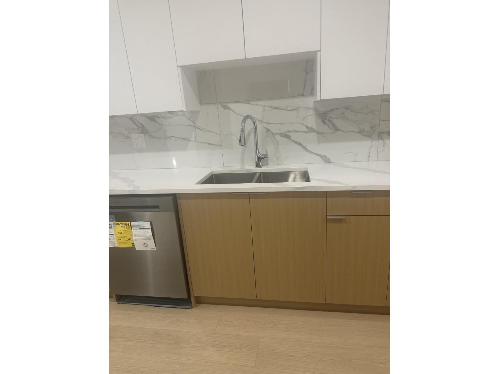 A kitchen with a sink and a fridge.