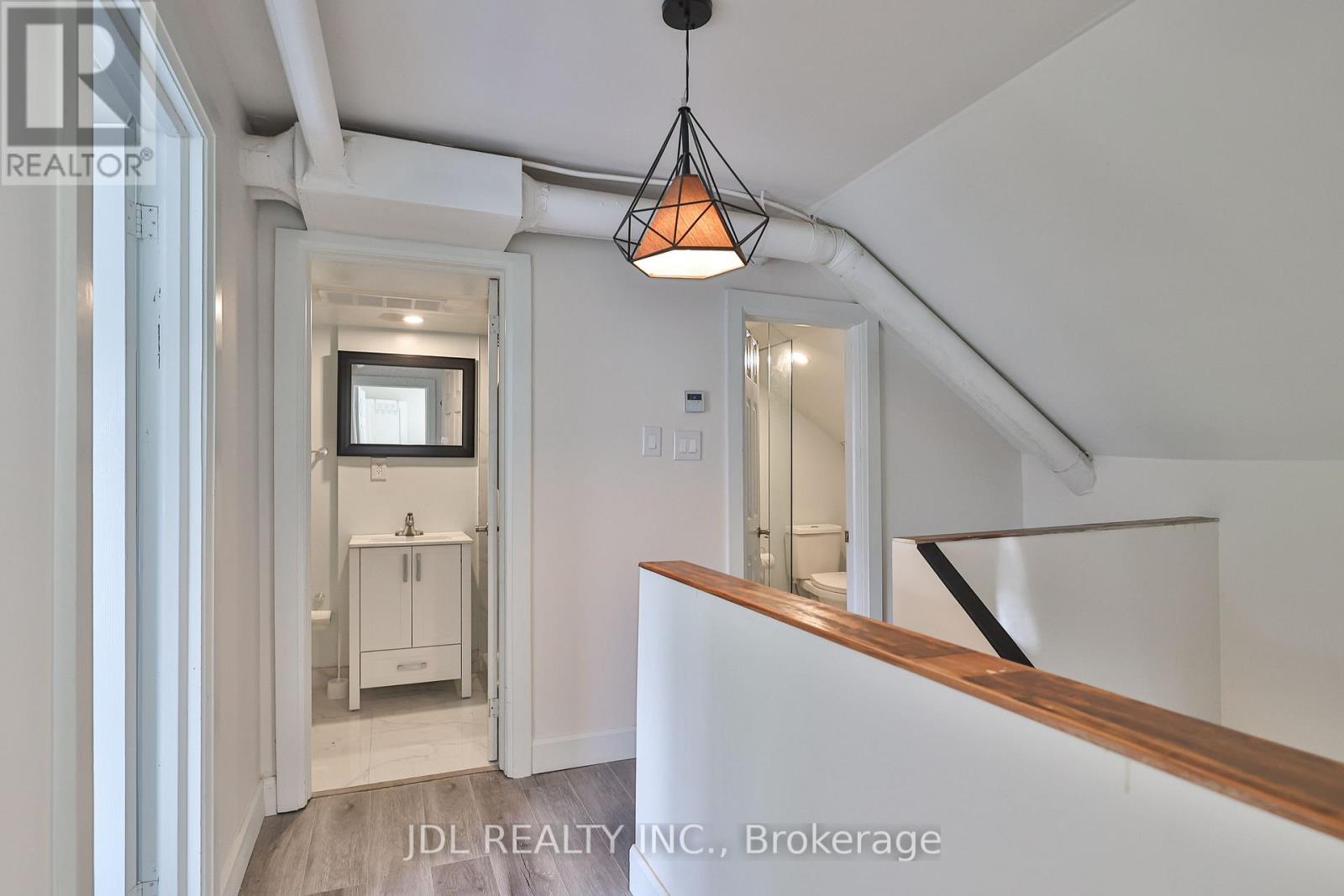 A white interior space with a hanging light fixture and a wooden counter.