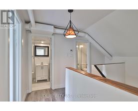 A white interior space with a hanging light fixture and a wooden counter.