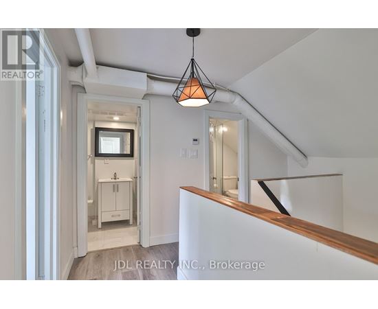 A white interior space with a hanging light fixture and a wooden counter.