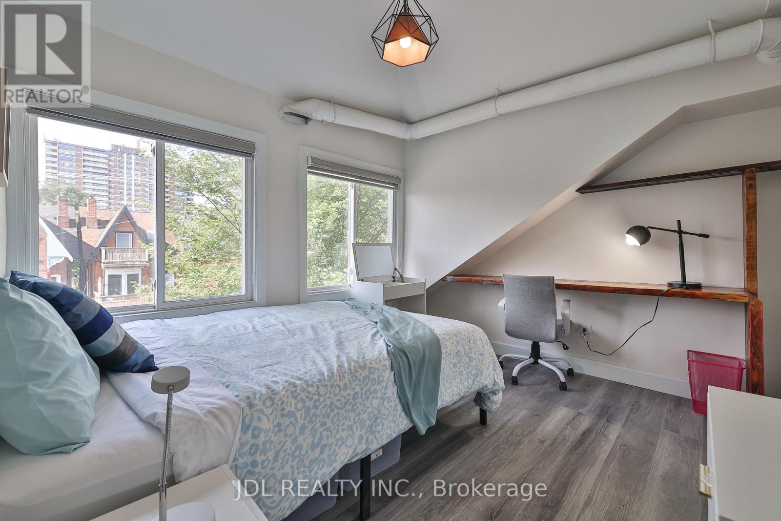 A bedroom with a bed, desk, and chair.