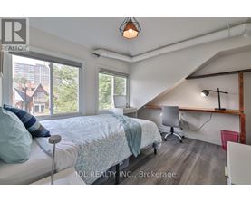 A bedroom with a bed, desk, and chair.