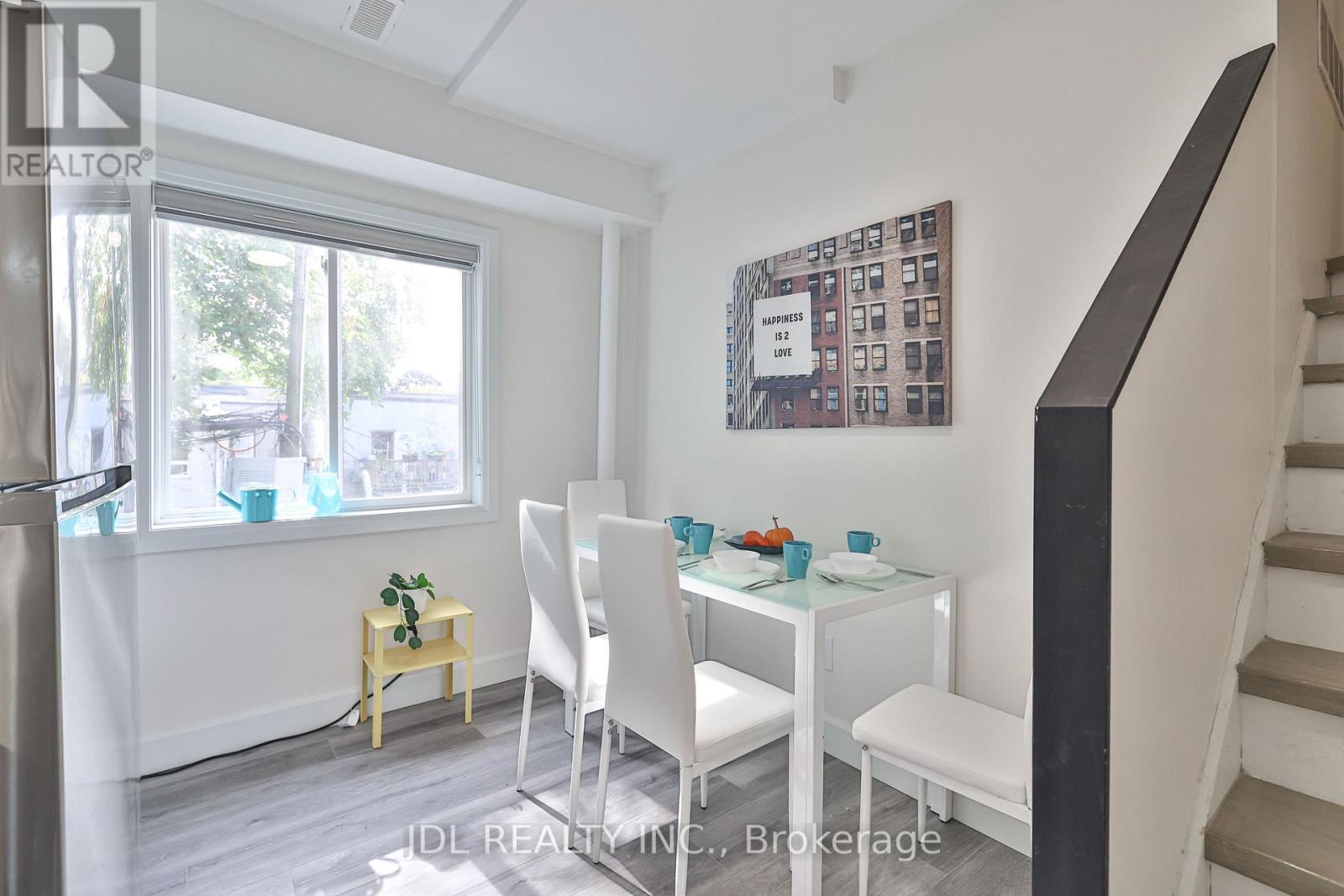 A dining room with a white table and chairs.
