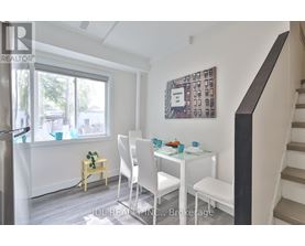 A dining room with a white table and chairs.