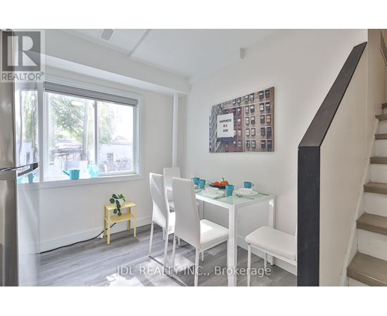 A dining room with a white table and chairs.