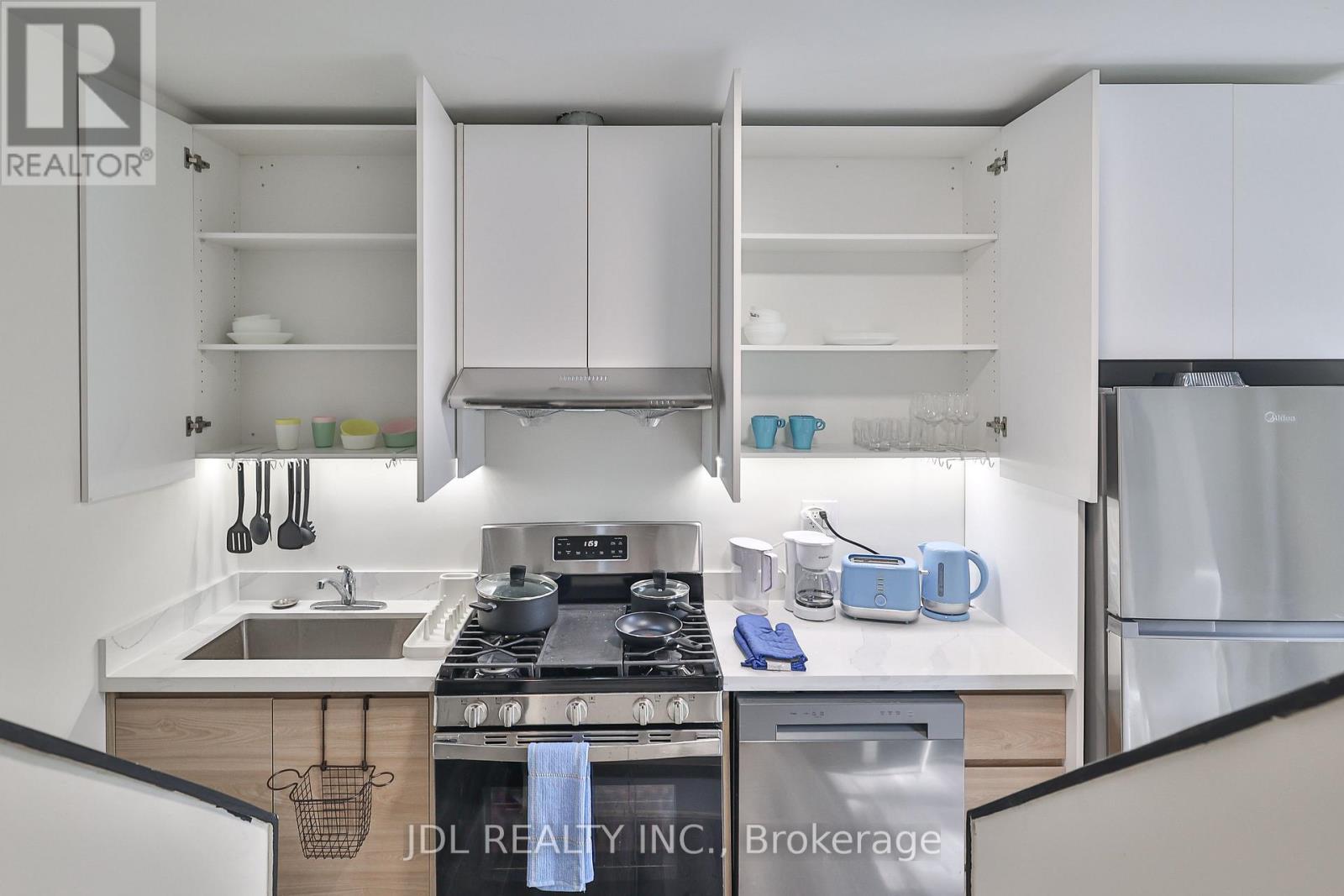 A modern kitchen with white cabinets and stainless steel appliances.