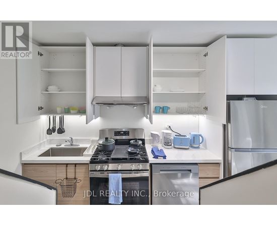 A modern kitchen with white cabinets and stainless steel appliances.