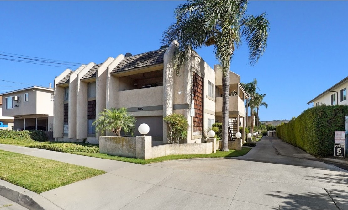 A modern house with a palm tree in front.