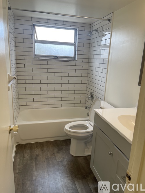A bathroom with a white tub, toilet, and sink.