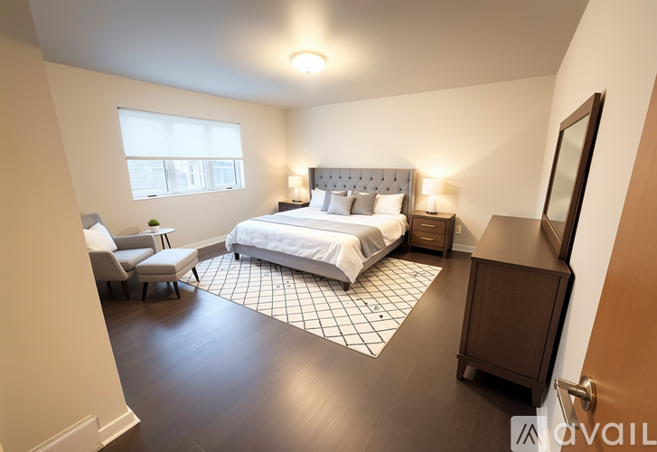A bedroom with a large bed and a chair.