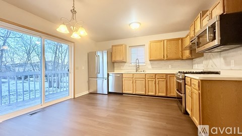 A kitchen with wooden cabinets and a black microwave above the stove.