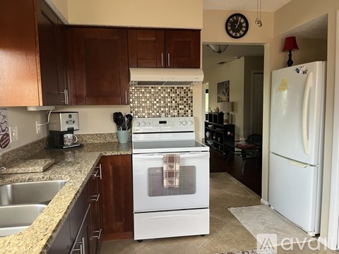A kitchen with a white stove and a white refrigerator.