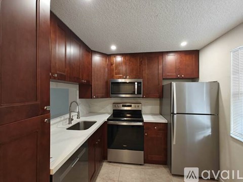 A kitchen with wooden cabinets and stainless steel appliances.