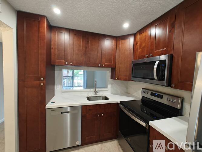 A kitchen with brown cabinets and white countertops.