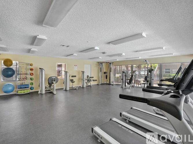 A gym with treadmills, exercise balls, and other equipment.