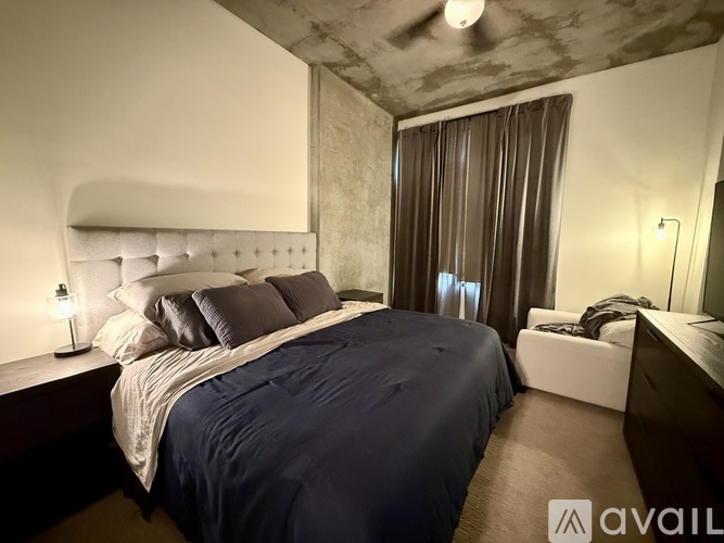 A bedroom with a large bed and a ceiling fan.