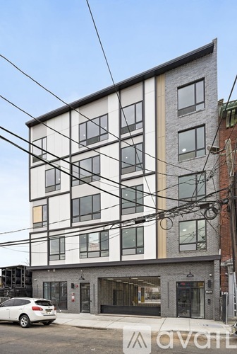 A modern building with a white car parked in front.