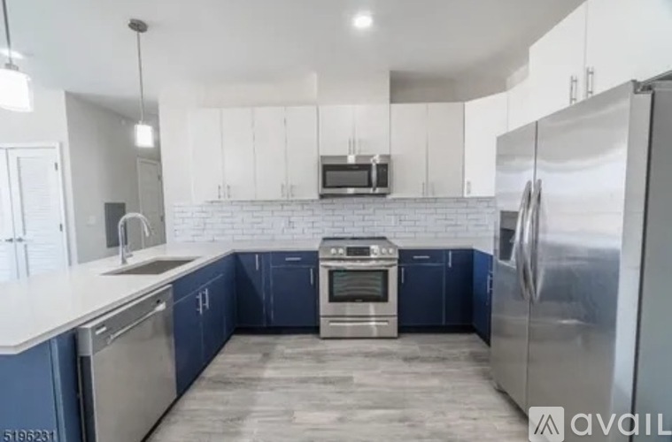 A modern kitchen with blue cabinets and stainless steel appliances.