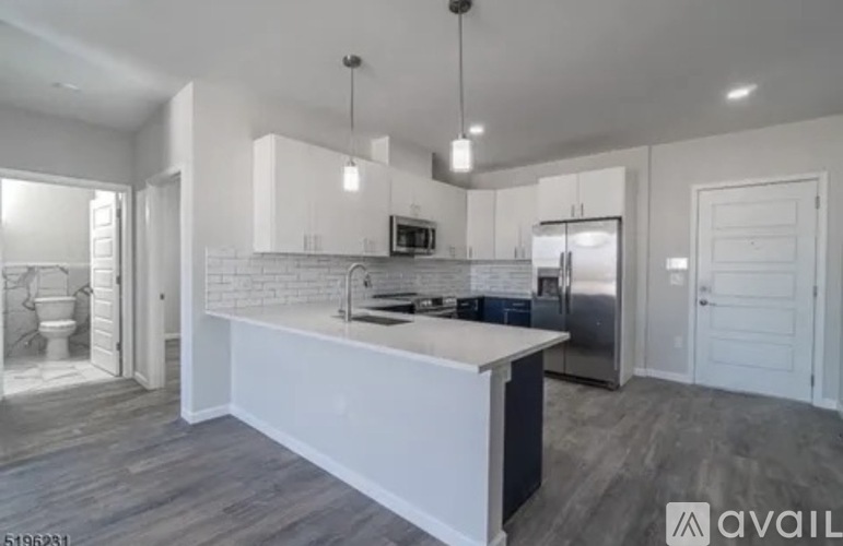 A modern kitchen with a large island and stainless steel appliances.