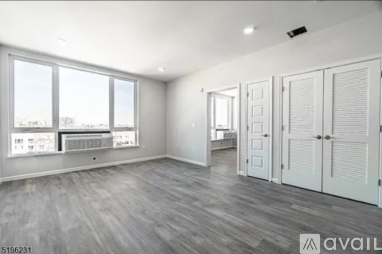A spacious room with a view of the city through large windows.