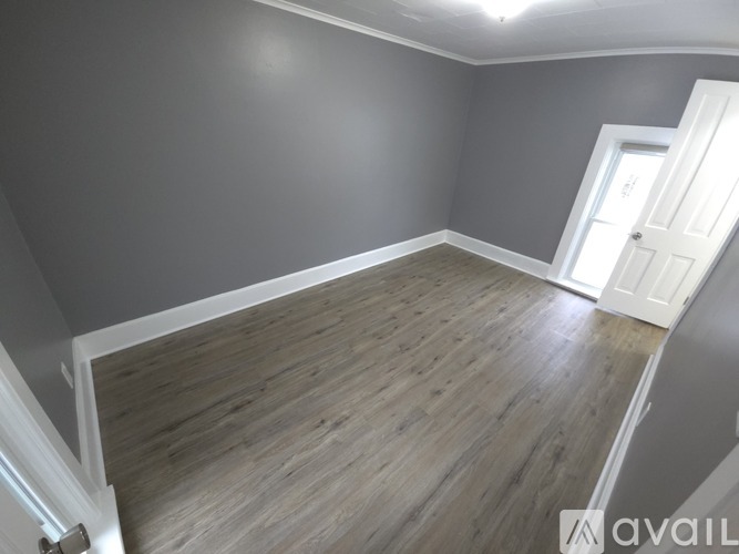 A room with wooden flooring and a white door.