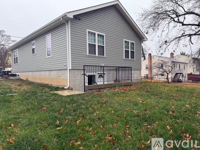 A grey house with a black iron fence in front.