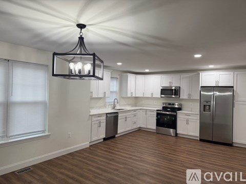 A modern kitchen with white cabinets and stainless steel appliances.