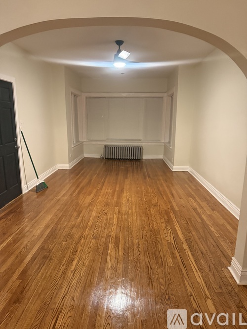 A room with wooden flooring and a black door.