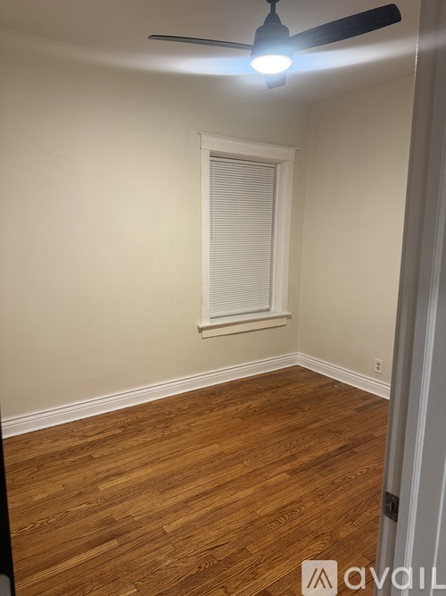 A room with wooden flooring and a ceiling fan.