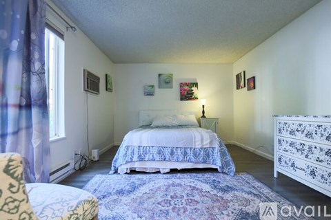 A bedroom with a bed, dresser, and chair.