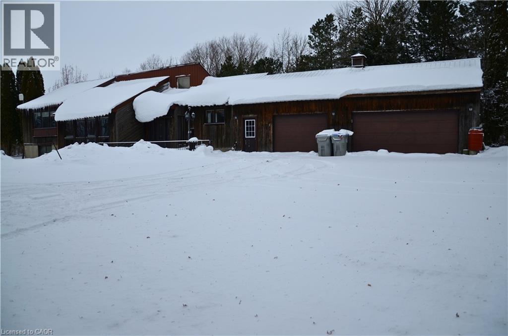 A snow covered house with a red garage door.