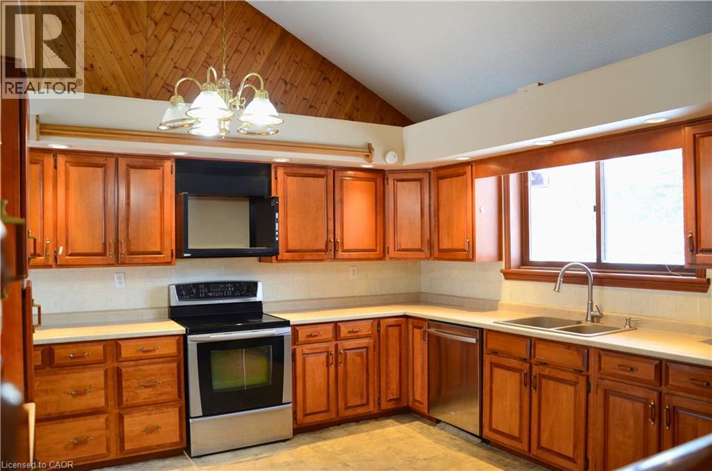 A kitchen with wooden cabinets and a stove top oven.