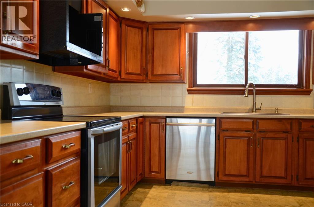 A kitchen with wooden cabinets and a stainless steel dishwasher.