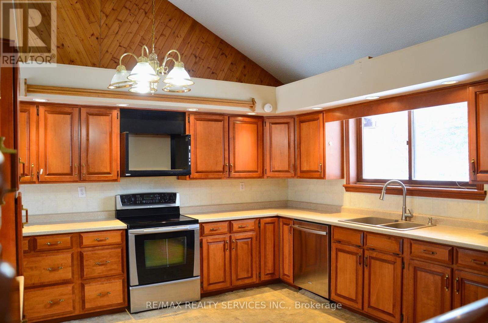 A kitchen with wooden cabinets and a stove top oven.