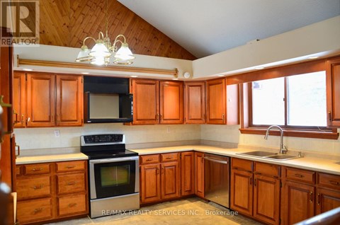 A kitchen with wooden cabinets and a stove top oven.