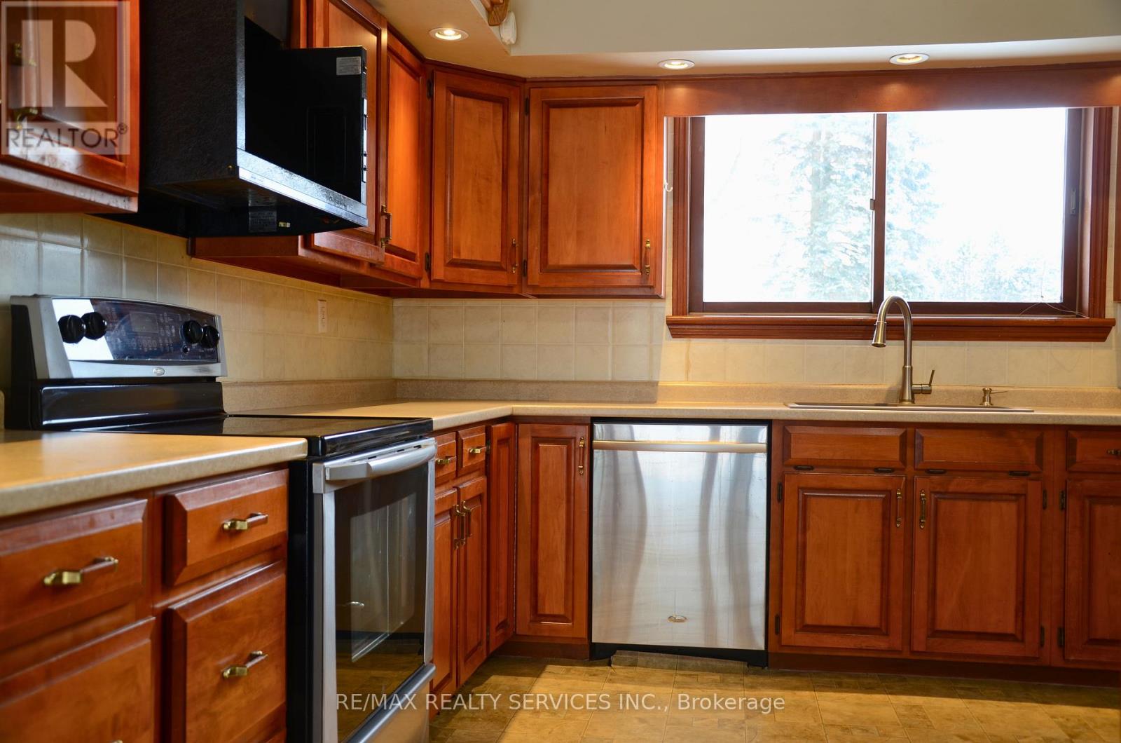 A kitchen with wooden cabinets and a stainless steel refrigerator.