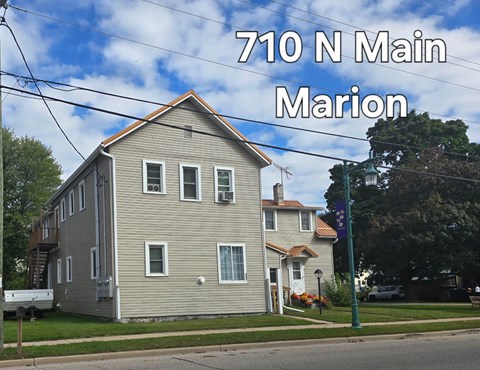 A two-story house with a grey facade and a red roof is located at 710 N Main in Marion.