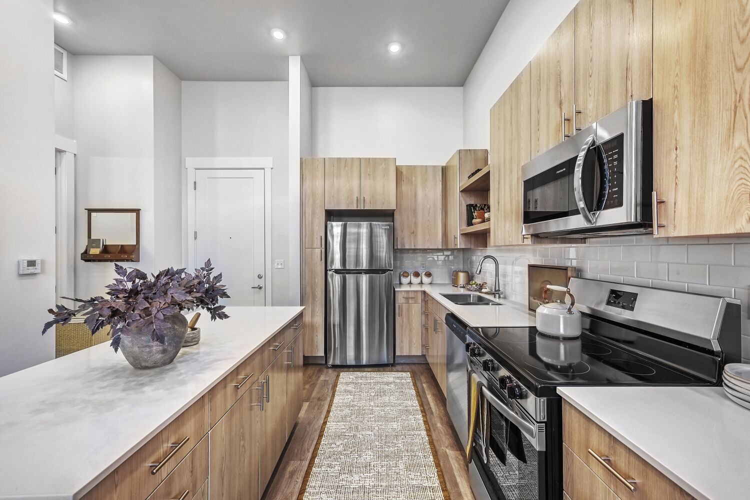 A modern kitchen with wooden cabinets and a marble countertop.
